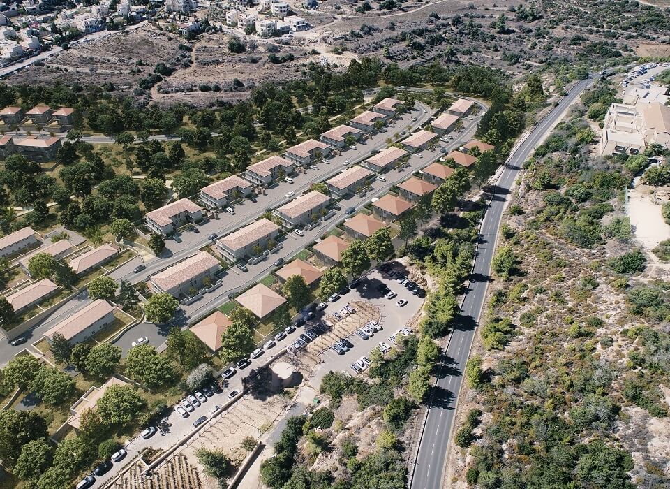 מבט מלמעלה על הפרויקט - שורות של בתים, מלא עצים, רכבים חונים וכביש